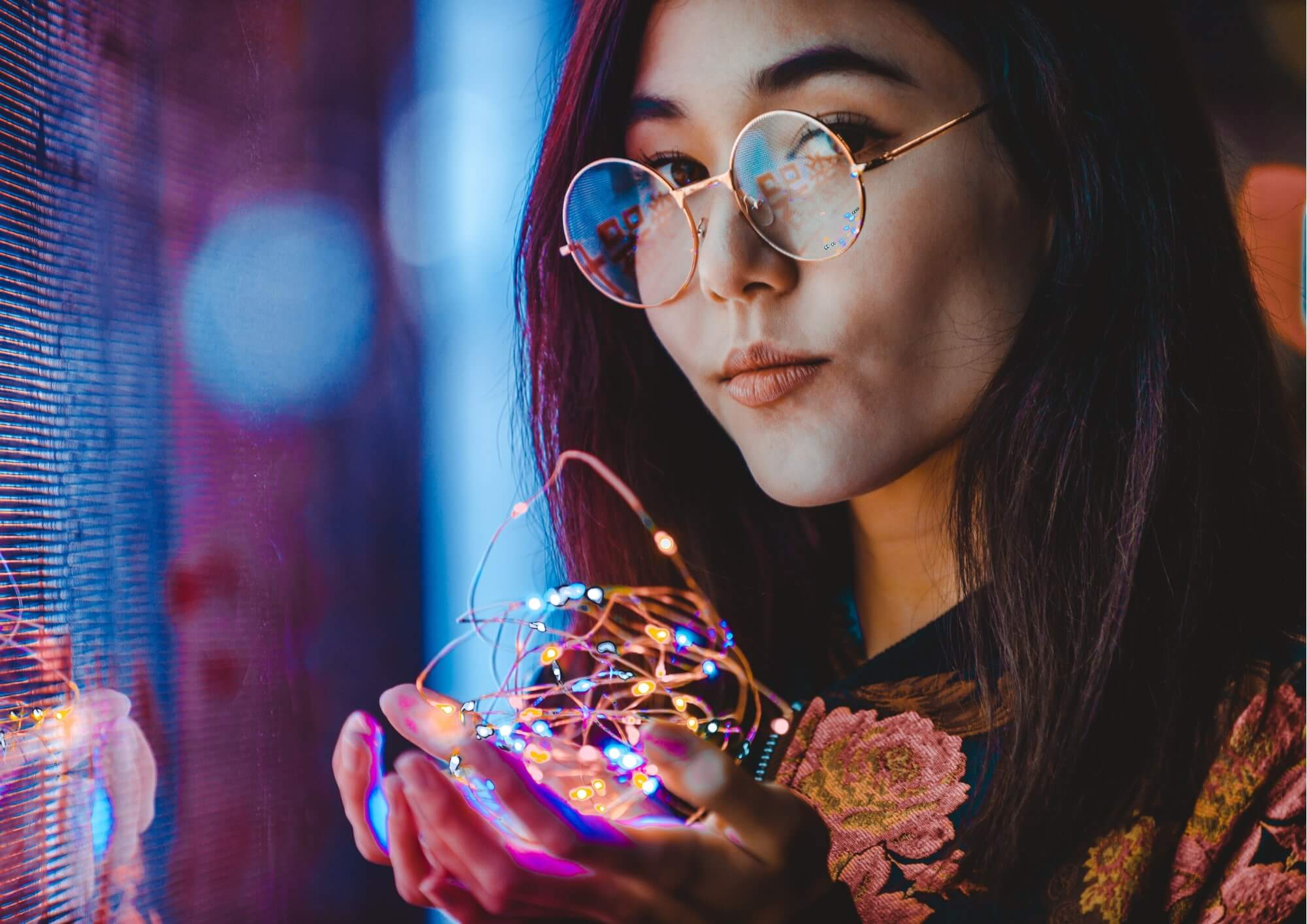 a woman holding a string of lights