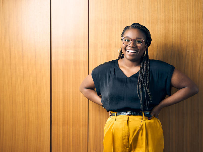 a person smiling with her hands on her hips