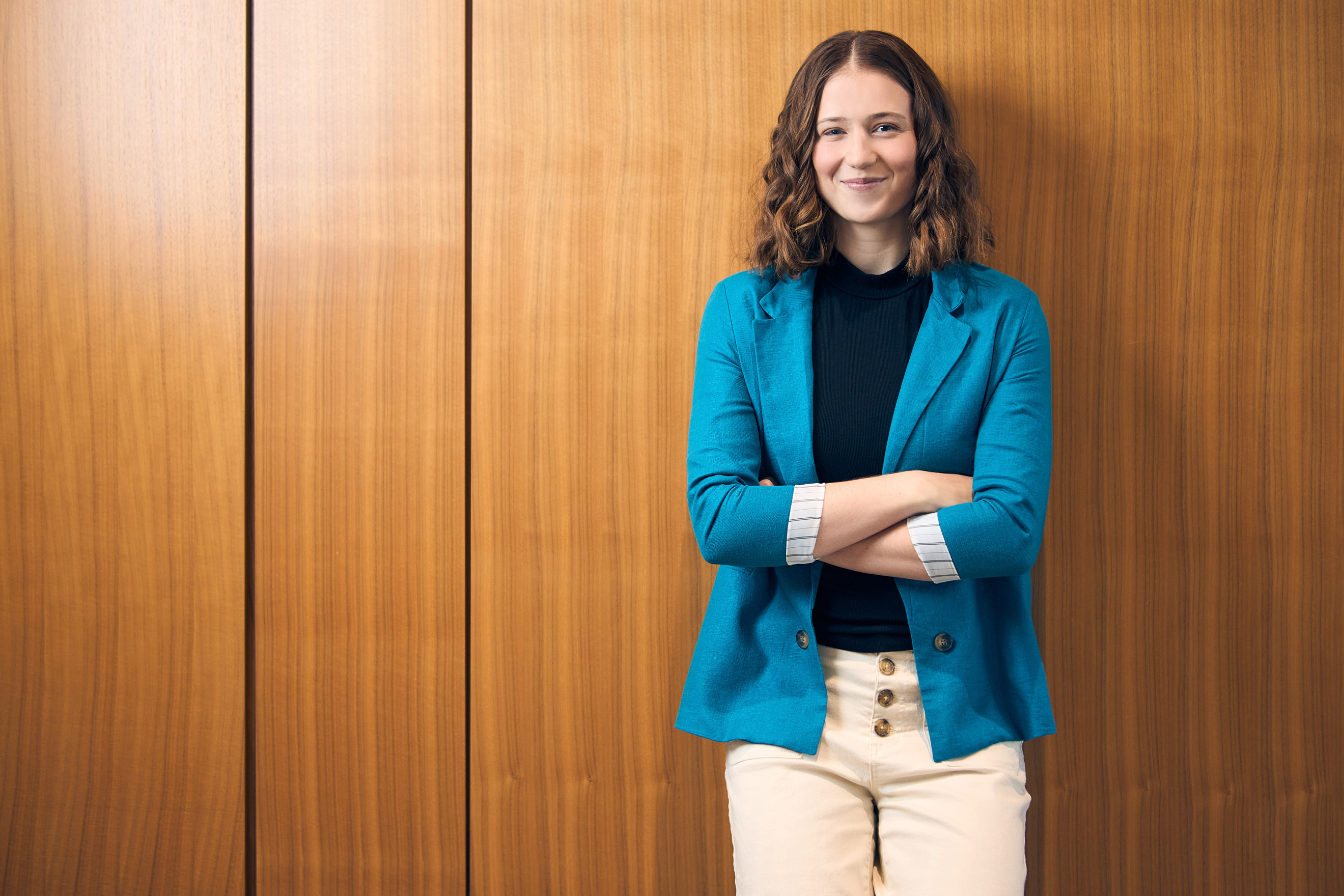 a person standing in front of a wood wall